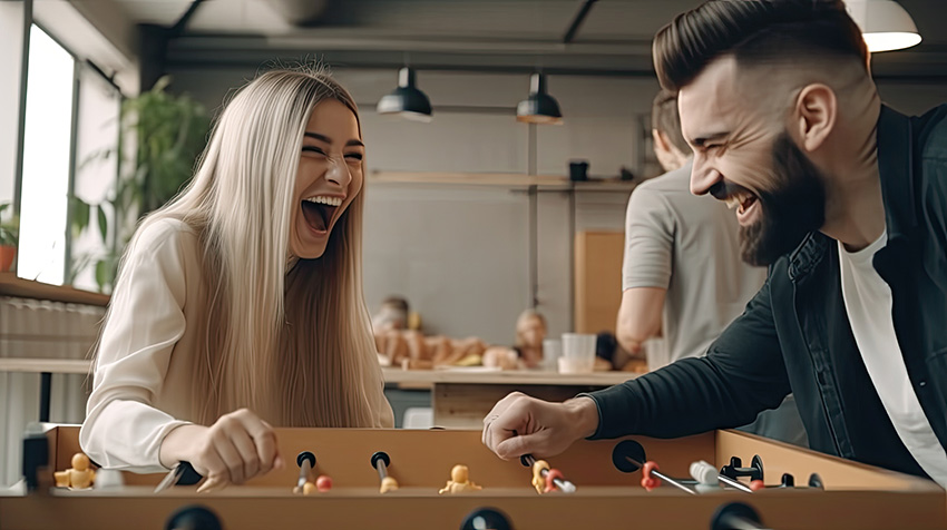 Joyful excited couple competing at Foosball