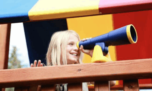 Child on Rainbow Playset using binoculars - available at Skillful Home in Maine